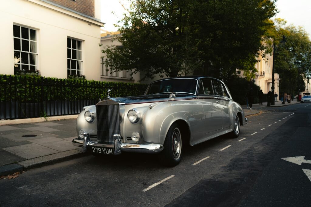 Classic silver Rolls Royce parked on a charming street in London, capturing timeless elegance.